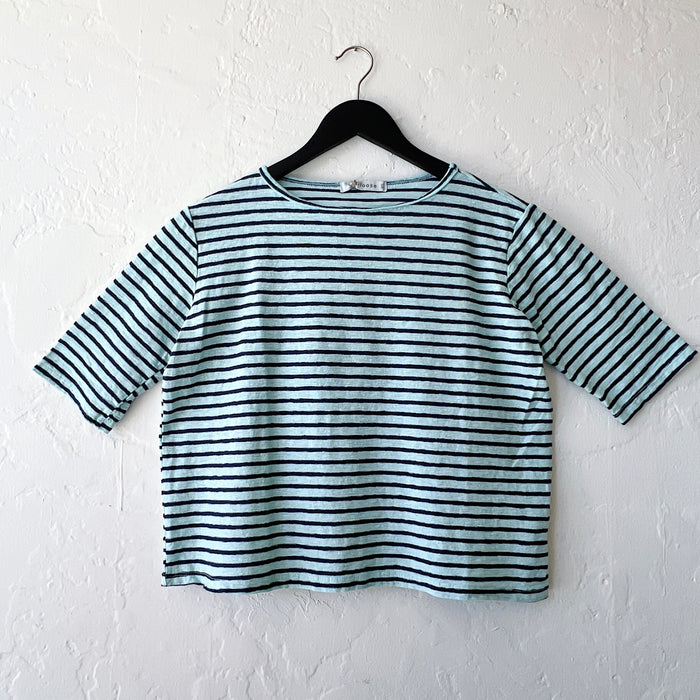 Striped shirt on a hanger against a white wall