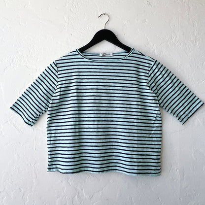 Striped shirt on a hanger against a white wall